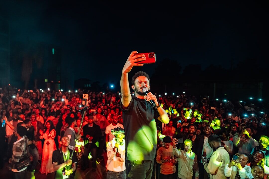 Videographer filming a local outdoor festival crowd
