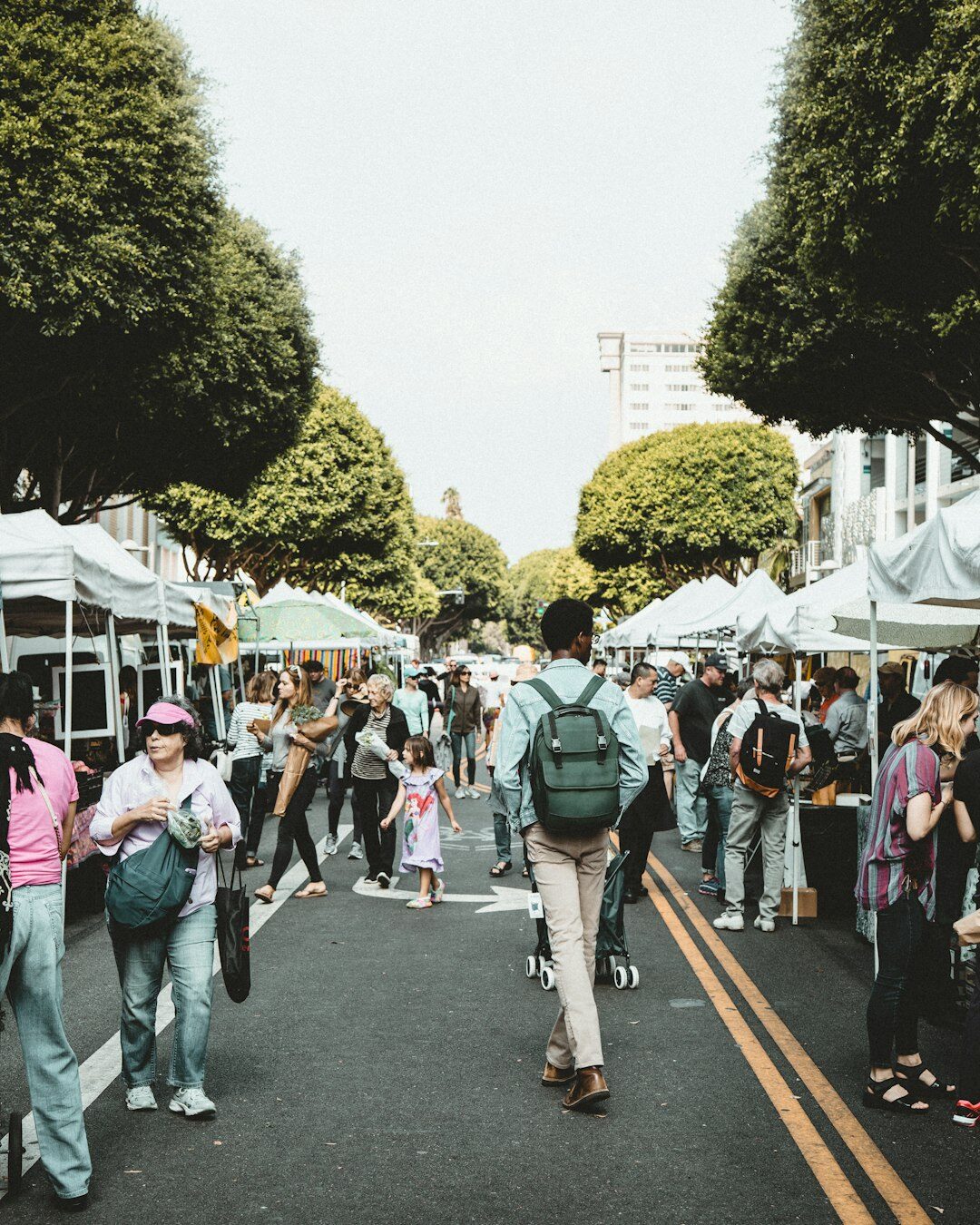Local outdoor market event with visitors and stalls